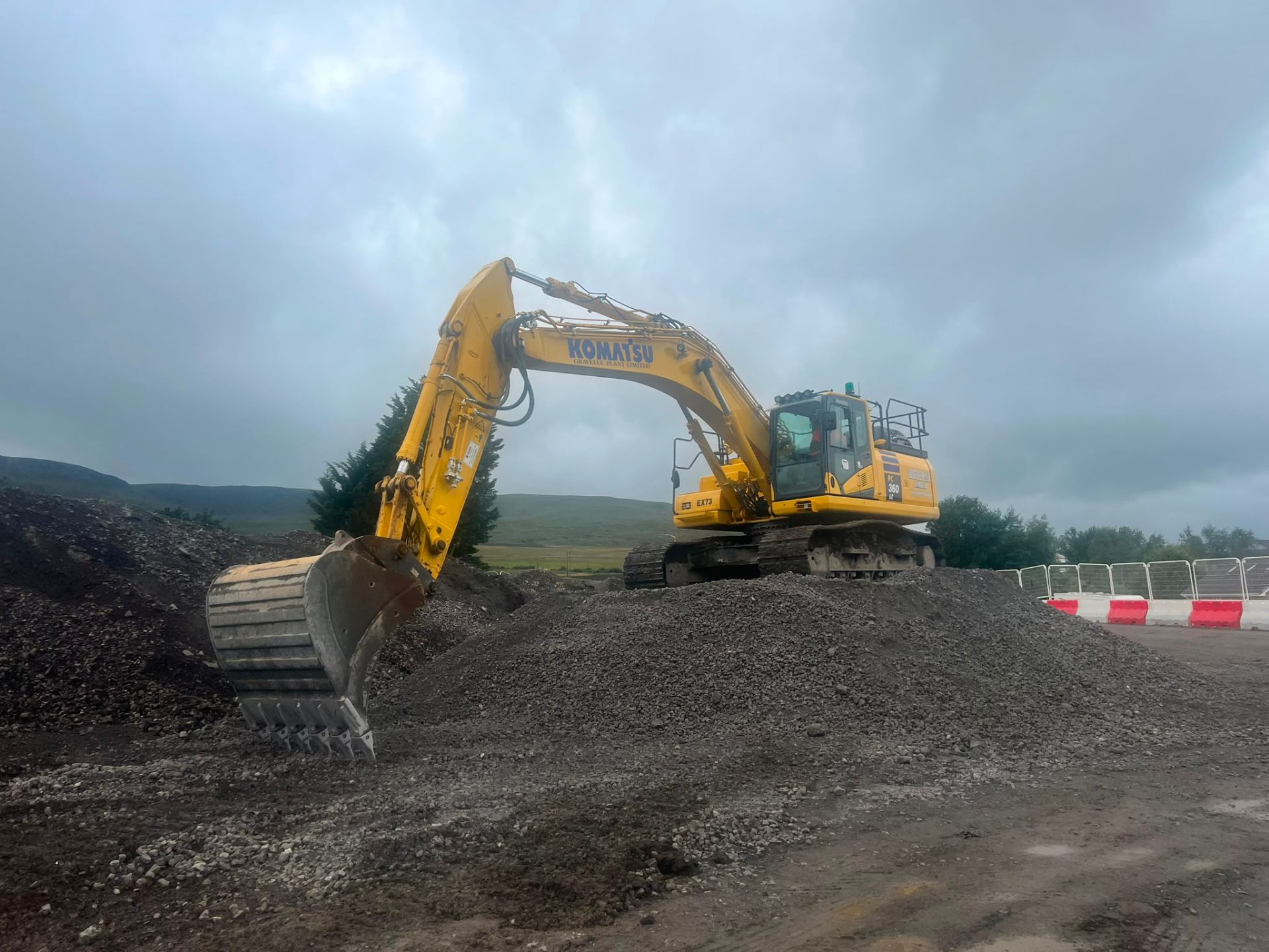 Yellow Komatsu tracked excavator on a South Wales groundwork site