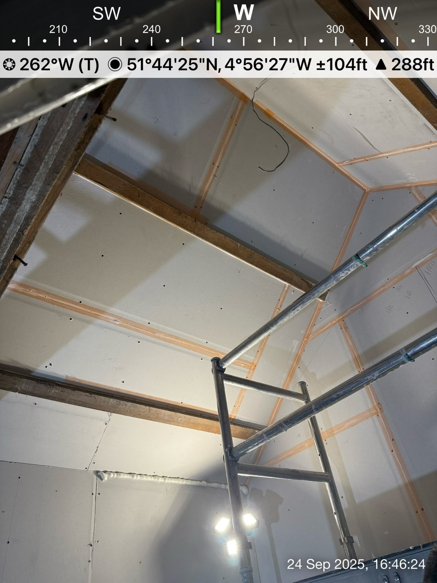 Low angle view of plasterboard sheets fixed to a vaulted ceiling showing screws and joints.
