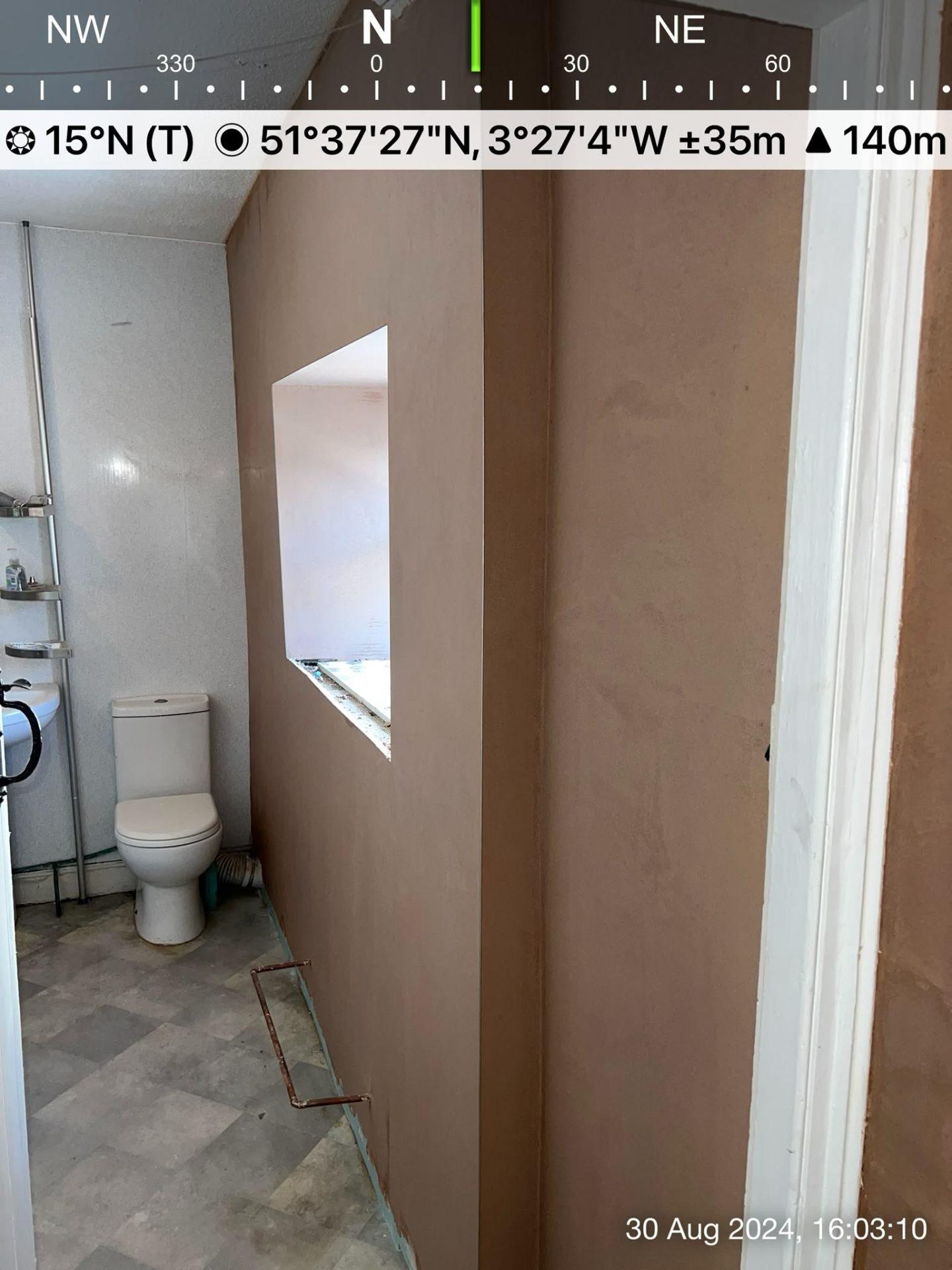 Newly plastered interior bathroom wall with smooth brown finish next to a white toilet.